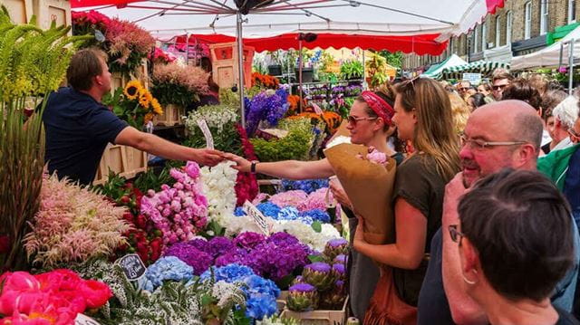 People buying from a stall at Columbia market in London